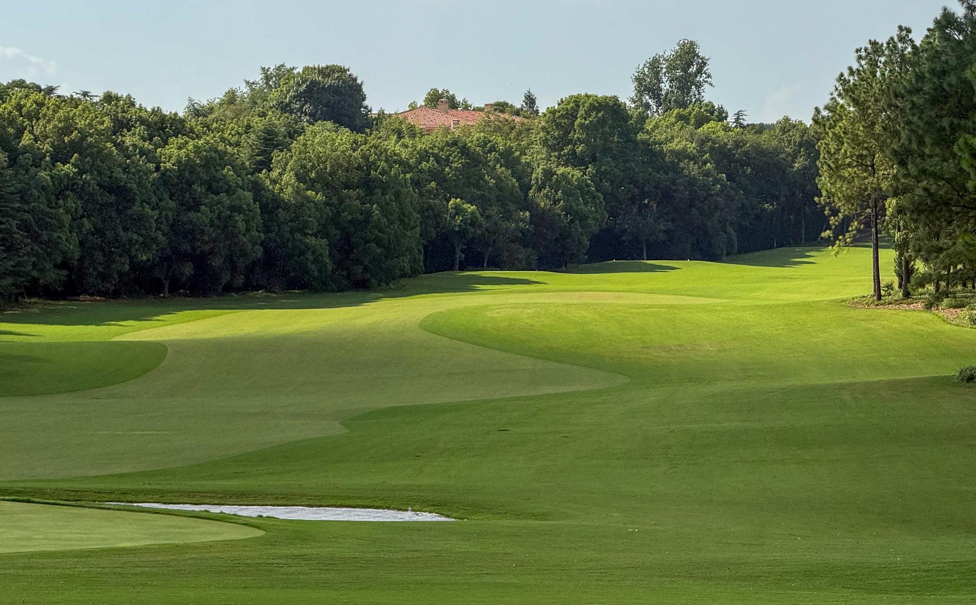 Golf course with trees and a pond