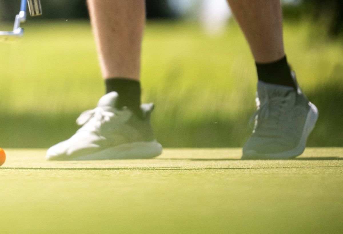 Golfer's shoes on a putting green