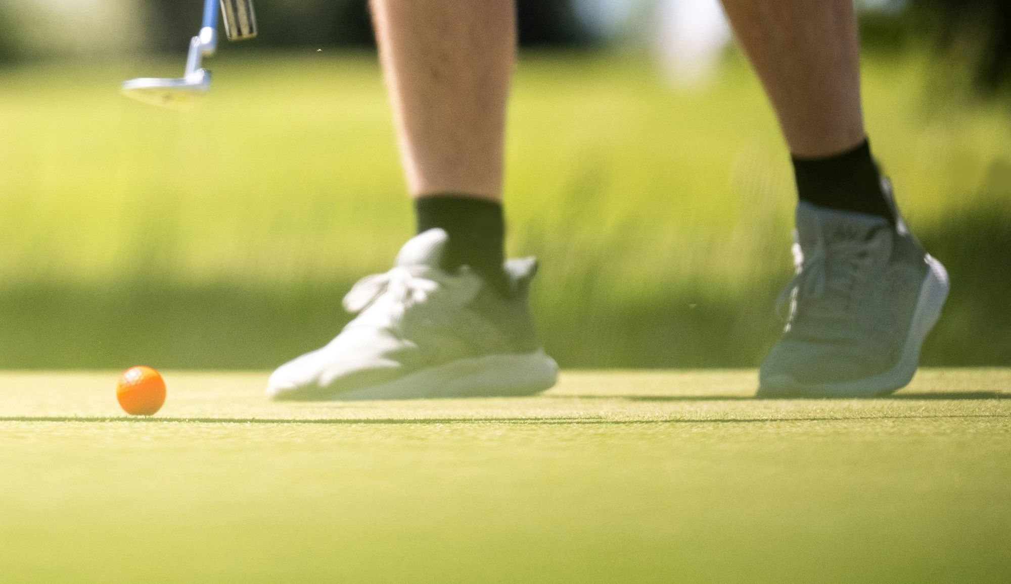 Golfers' shoes on a putting green